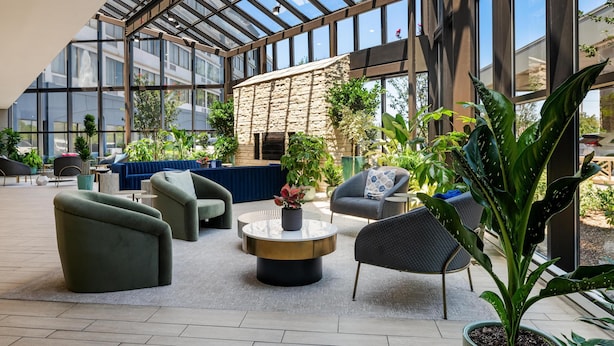 A spacious indoor area with a high ceiling, large windows, and comfortable seating arrangements. - DoubleTree by Hilton Fairfield Hotel & Suites (Fairfield)