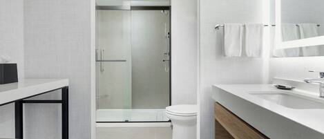 Une salle de bain moderne équipée d’une douche, de toilettes et d’un meuble-lavabo.