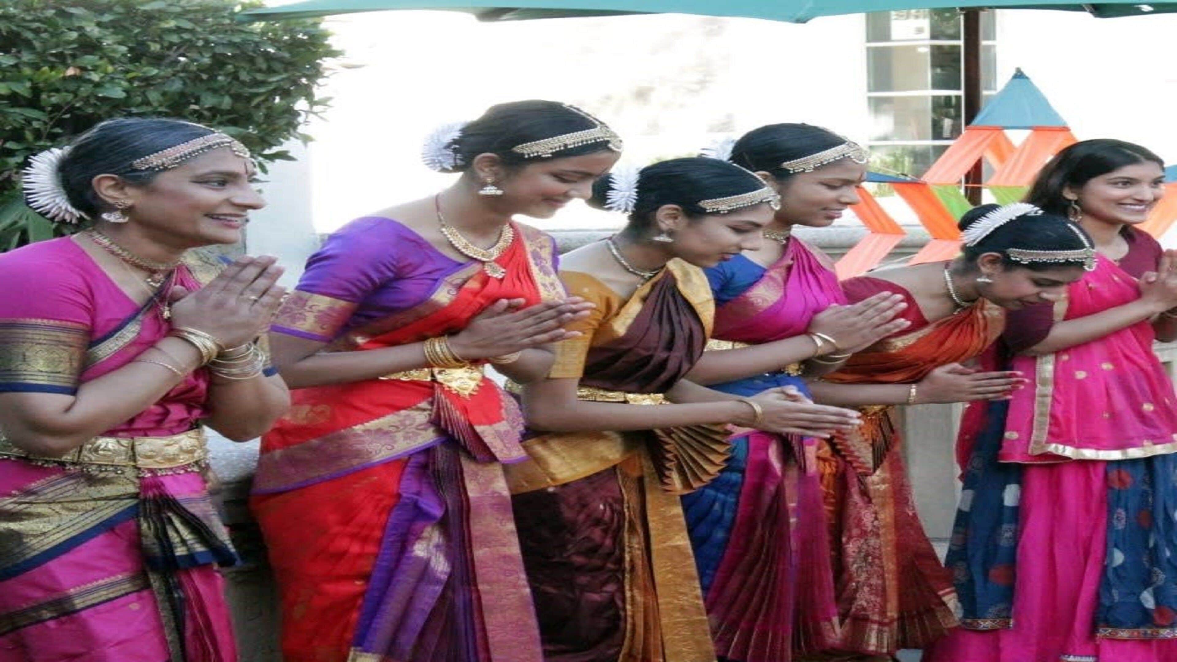 A group of women in traditional attire standing in a line, possibly at an event or ceremony.