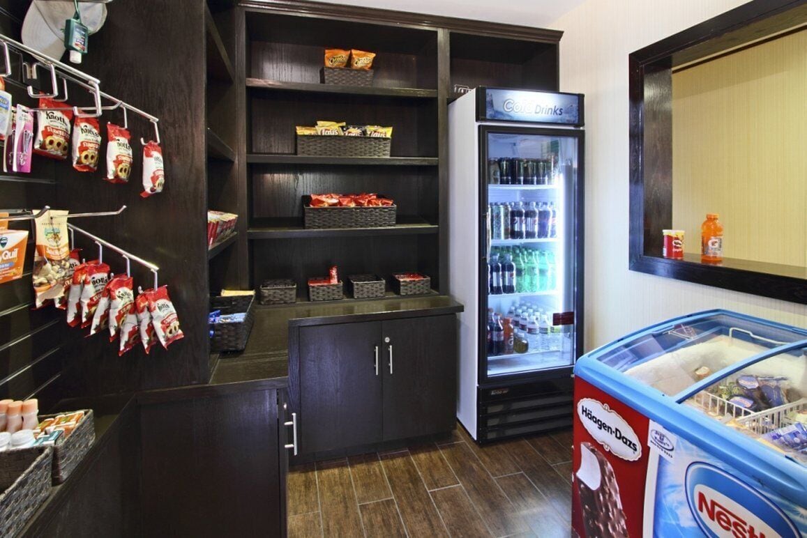 A hotel room with a minibar, a refrigerator stocked with beverages, and a Nestle ice cream freezer.