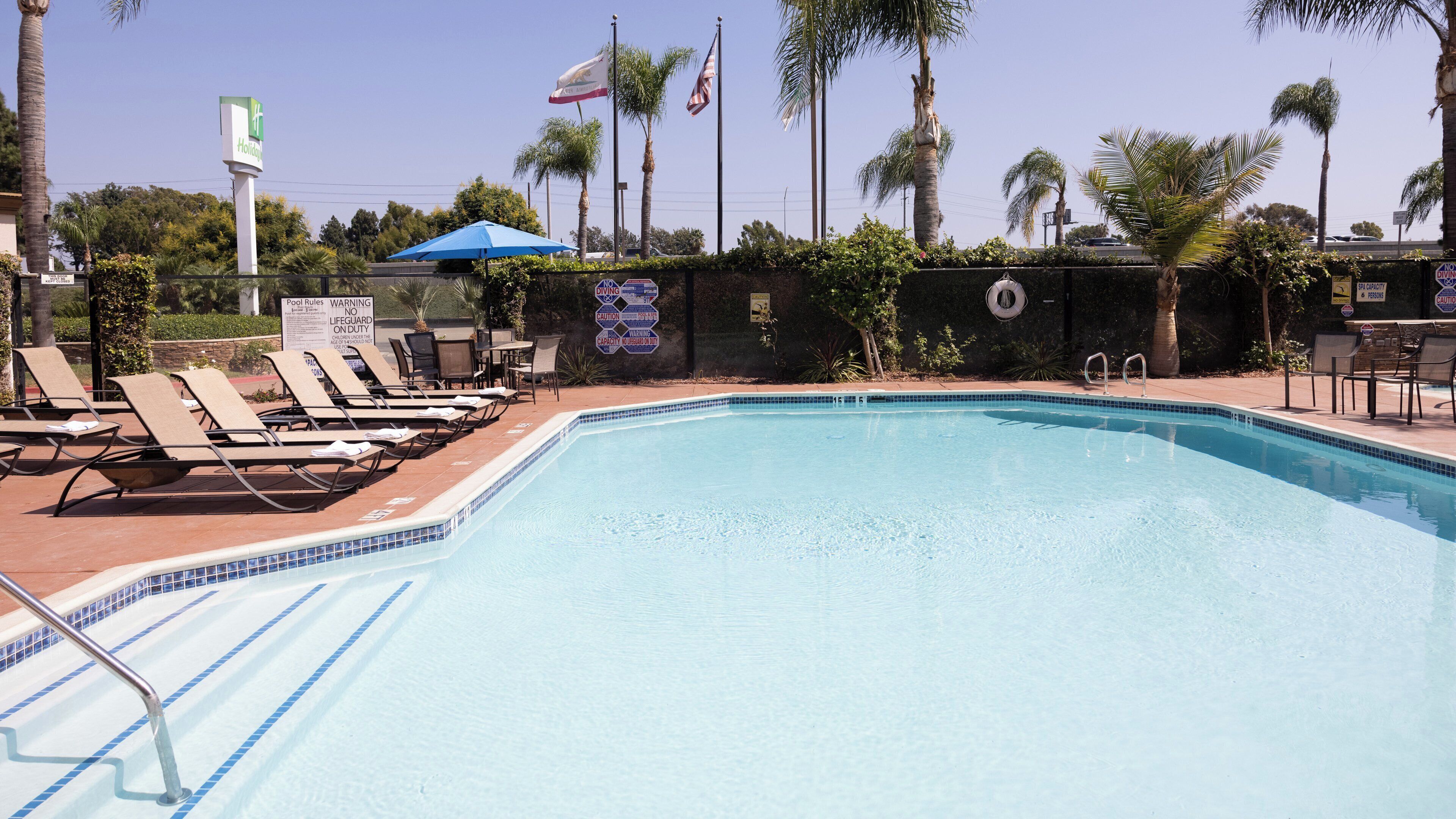 A swimming pool with lounge chairs and a lifeguard tower.