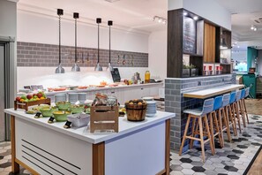 A breakfast bar with various food items and a seating area with chairs. - Holiday Inn Haydock M6 Jct23 by IHG (Newton-le-Willows)