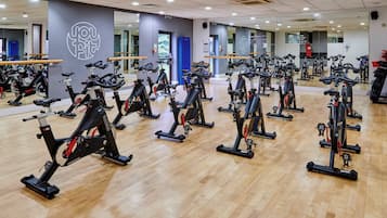 Un gimnasio con varias bicicletas estáticas dispuestas en filas.