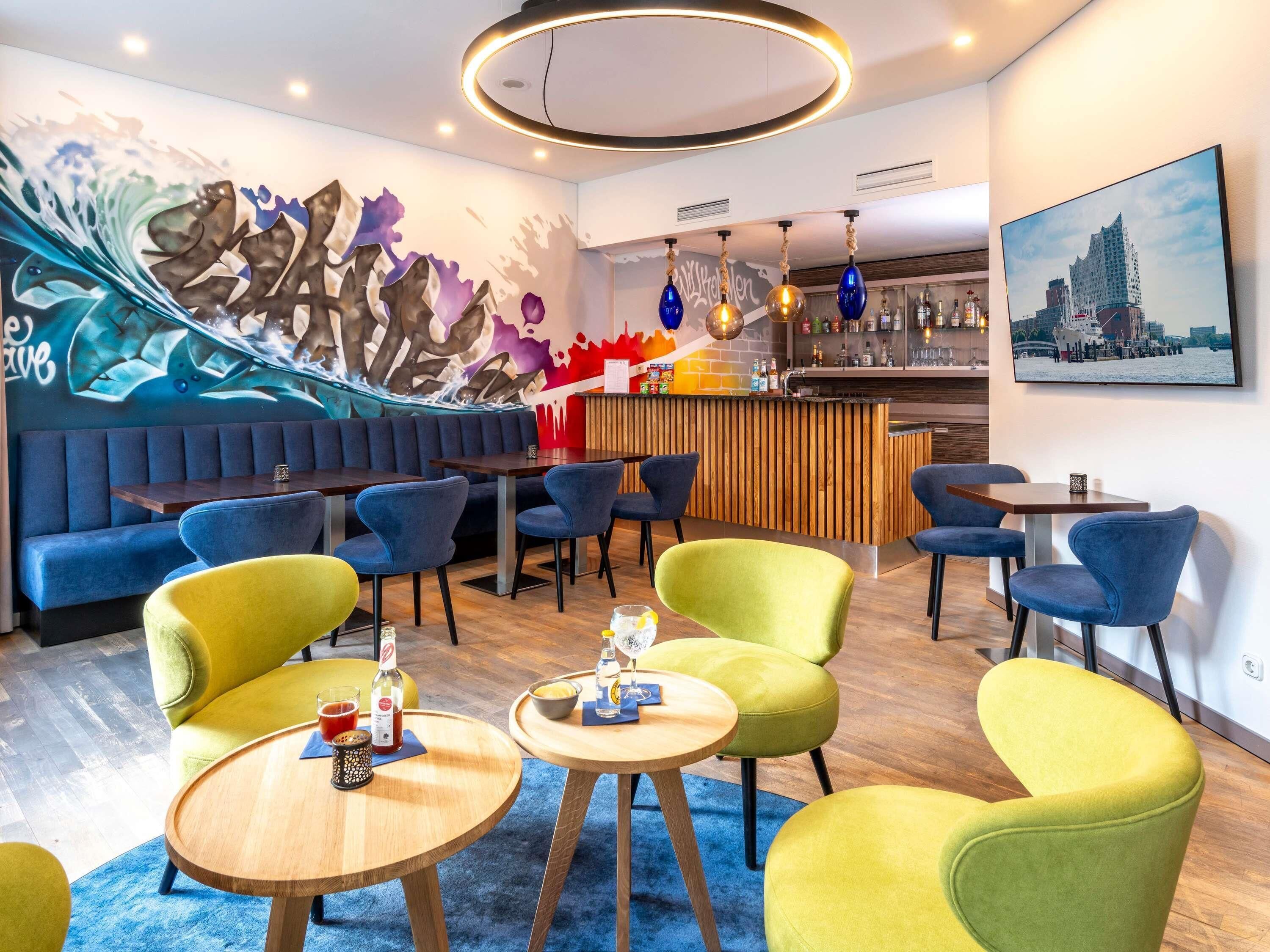 A modern bar area with a mural, seating, and a cityscape view.