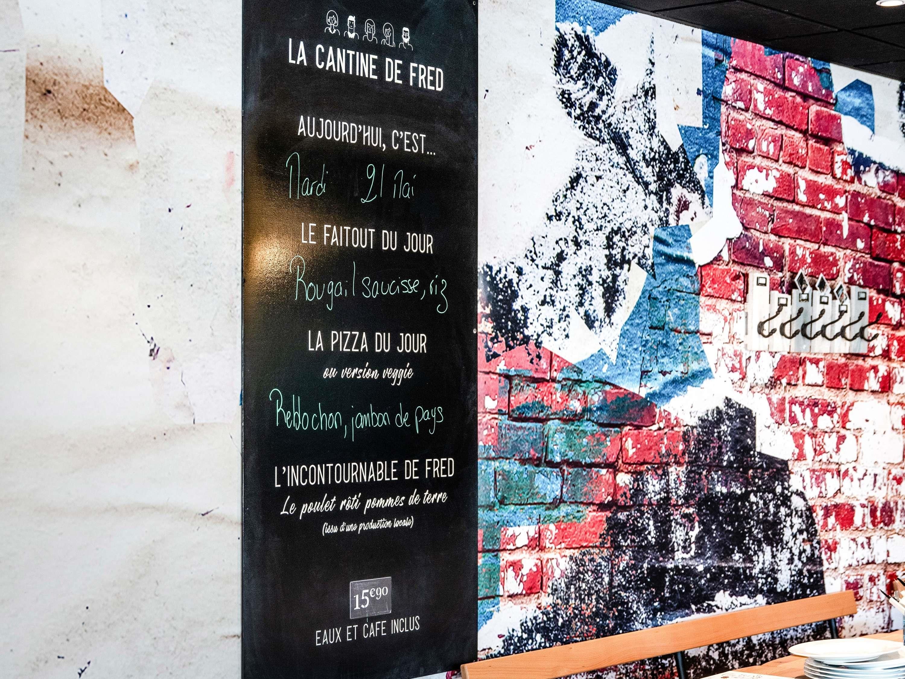 A menu board with daily specials and a mural on the wall.