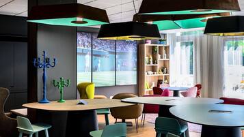 Un interior moderno con mesas redondas, sillas coloridas e iluminación colgante.