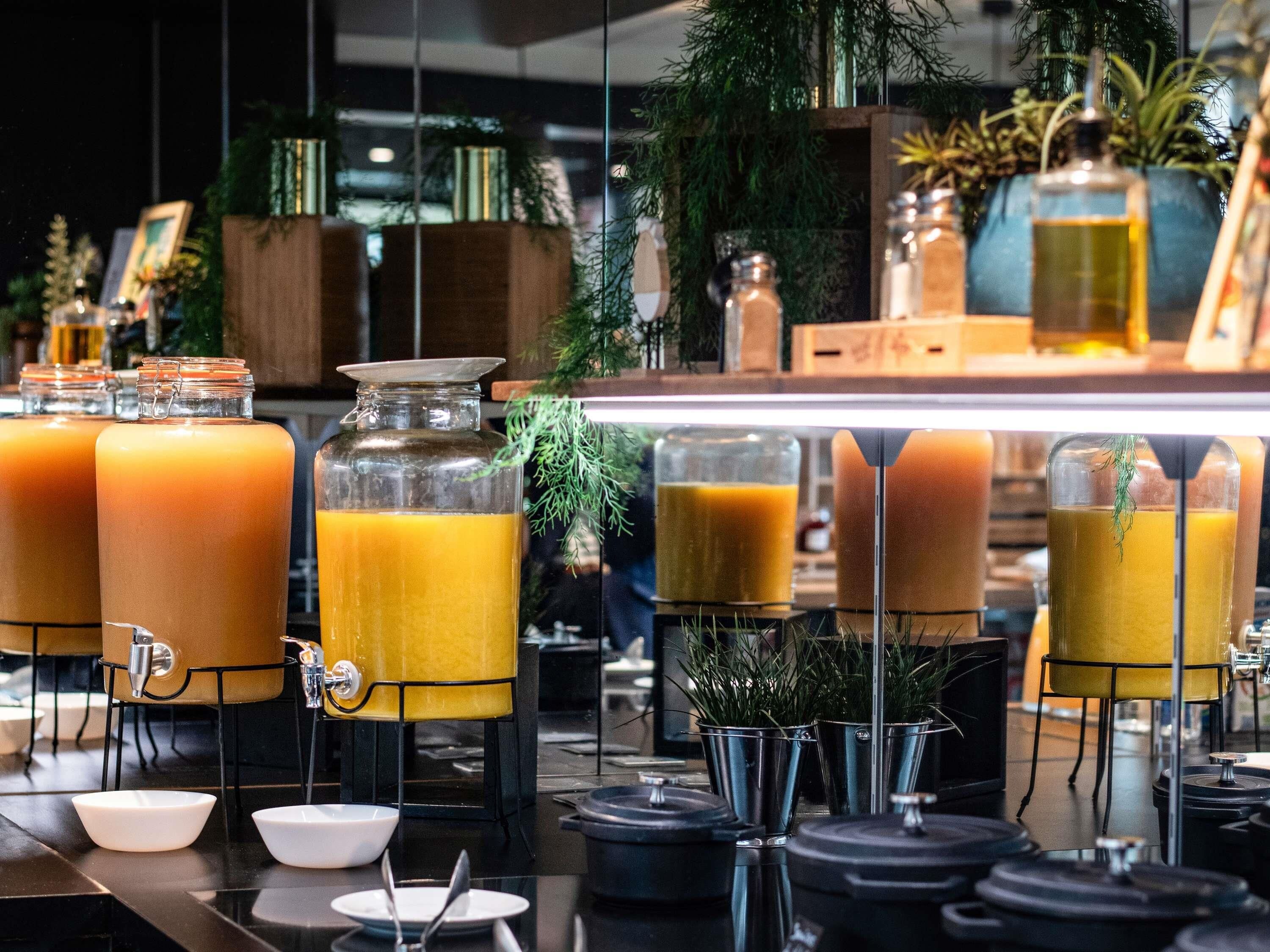 Zona de bar con varios dispensadores de bebidas, un lavamanos y una barra.