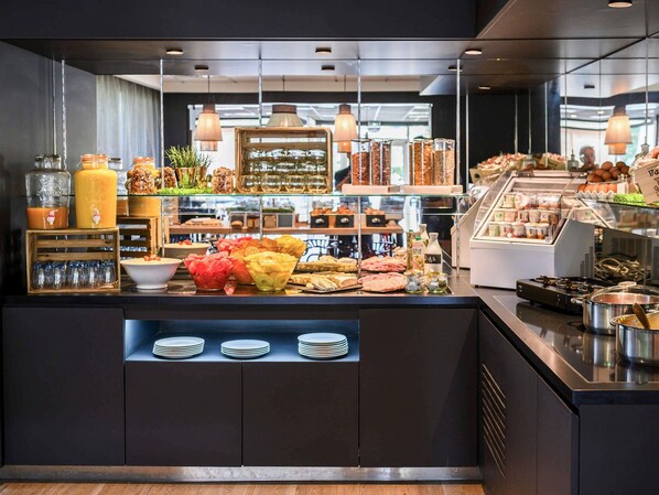 Un bufé de desayuno con diferentes opciones de comida, frascos de vidrio y una máquina de café.