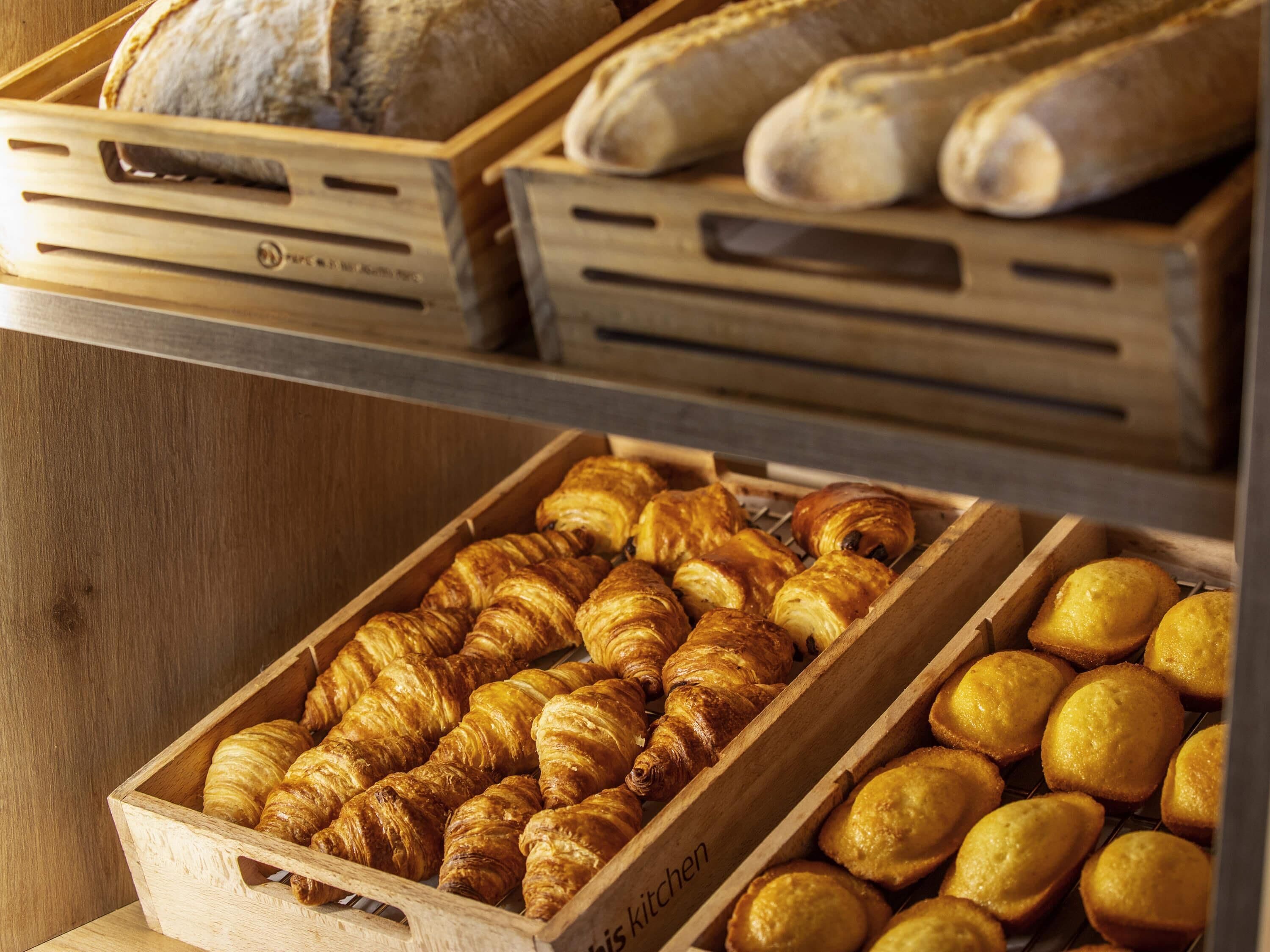 Wooden crates filled with baked goods, including croissants and muffins.