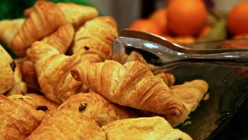 Un bol rempli de croissants, accompagné d’une pince.