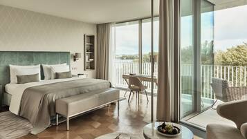 Ett modernt hotellrum med en stor säng, en balkong med utsikt och en matplats.