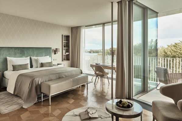 Une chambre d’hôtel moderne dotée d’un grand lit, d’un balcon avec vue et d’un coin repas.
