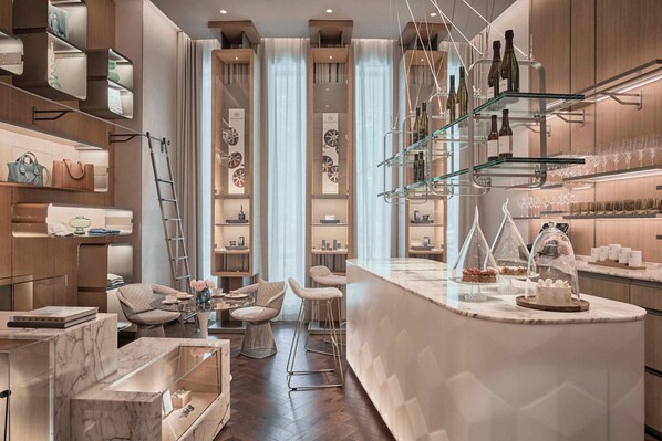 Una cocina moderna con encimera de mármol, estanterías para vinos y taburetes de bar.