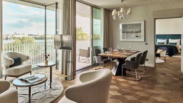 A modern hotel room with a large balcony, a dining area, and a bedroom.