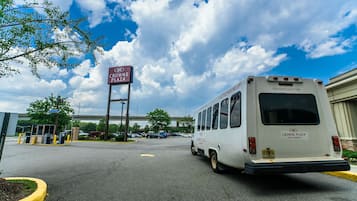 A parking lot with a bus and a sign for Crowne Plaza.