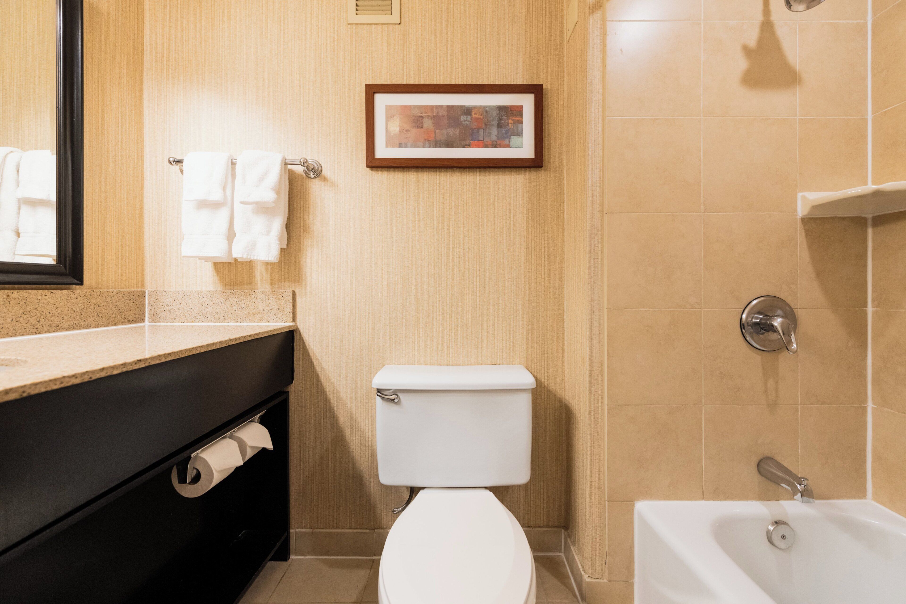 Een badkamer met toilet, wastafel en bad.
