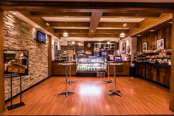 A bakery with a stone wall, wooden ceiling, and a display case with baked goods. - Crowne Plaza Newark Airport by IHG (Elizabeth)