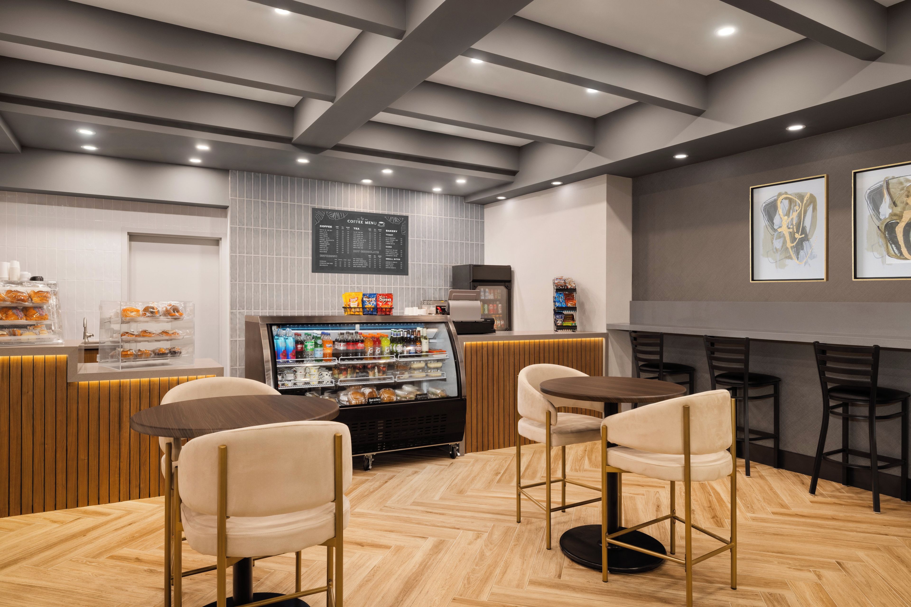 A cafe interior with a counter, seating area, and a menu board.