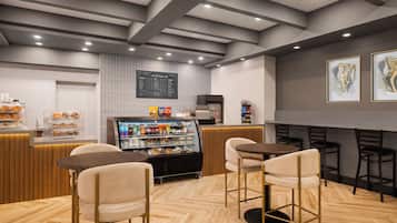 A cafe interior with a counter, seating area, and a menu board.