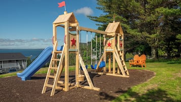 Children can play on the playground's slide, swings, and climbing area.