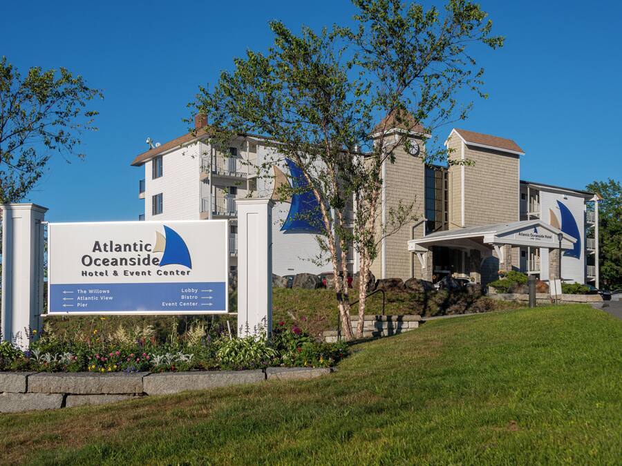A hotel sign for Atlantic Oceanside Hotel & Event Center with directional arrows to The Willows, Atlantic View, and Pier.
