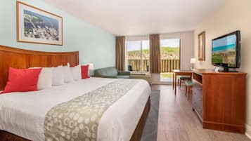 Habitación de hotel con una cama grande, un escritorio, televisión y ventana con vistas al exterior.