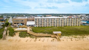 Un hôtel en bord de mer, doté d’une promenade qui mène à la plage, de nombreux balcons et d’une vue sur l’océan.