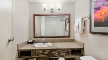 A bathroom with a sink, mirror, and toilet.