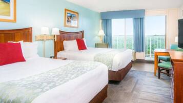 Une chambre d’hôtel avec deux lits, un bureau et une télévision.