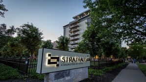 A sign for Strathallan, a doubletree by Hilton, with a stone base and illuminated letters. - The Strathallan Rochester Hotel & Spa, Tapestry by Hilton (Rochester)