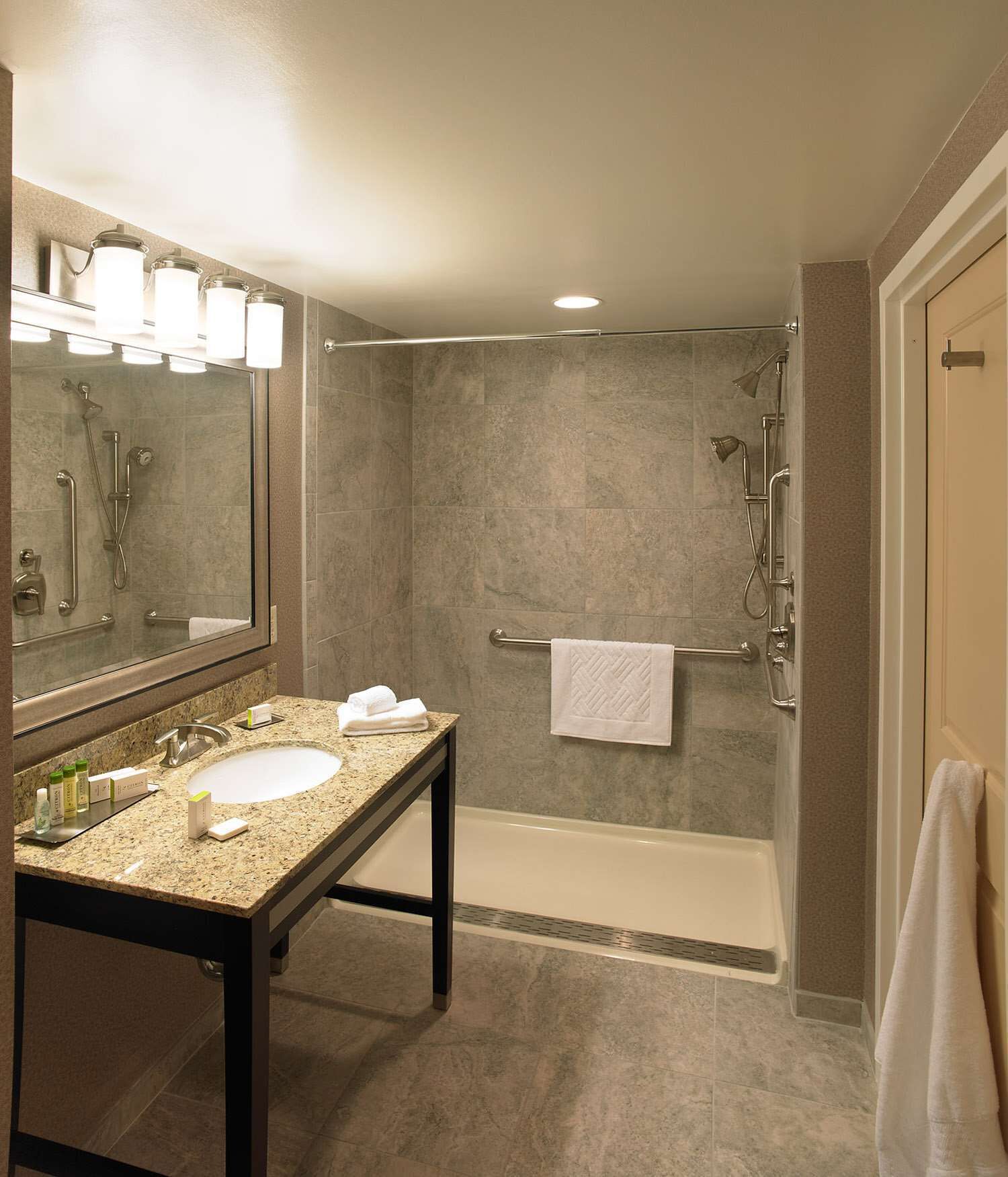 A modern bathroom with a double sink vanity, a glass shower enclosure, and a separate bathtub.