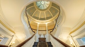 A grand staircase with ornate balustrades and a dome ceiling with a stained glass window. - The Strathallan Rochester Hotel & Spa, Tapestry by Hilton (Rochester)