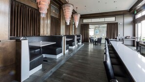 A modern bar area with high stools and a long counter. - The Strathallan Rochester Hotel & Spa, Tapestry by Hilton (Rochester)