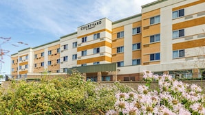 Un hotel Courtyard by Marriott con un diseño moderno, varios pisos y techo plano.