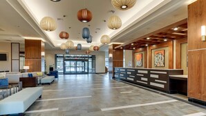 A spacious lobby with a reception desk, seating area, and decorative hanging lights. - Drury Plaza Hotel Orlando - Disney Springs Area (Lake Buena Vista)