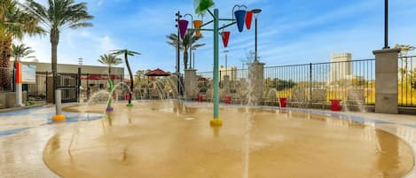 A water play area with multiple fountains and colorful play structures.
