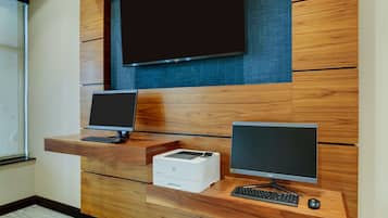 A reception desk with two monitors, a printer, and a keyboard.