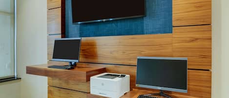 A reception desk with two monitors, a printer, and a keyboard.