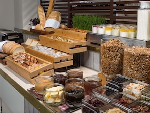 A buffet with various food items including bread, pastries, and condiments. - Pullman Melbourne City Centre (Melbourne)