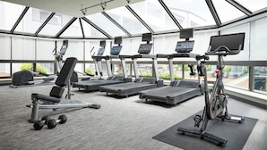 A modern gym with treadmills, elliptical machines, and weight benches. - Courtyard by Marriott St Louis Westport Plaza (Maryland Heights)