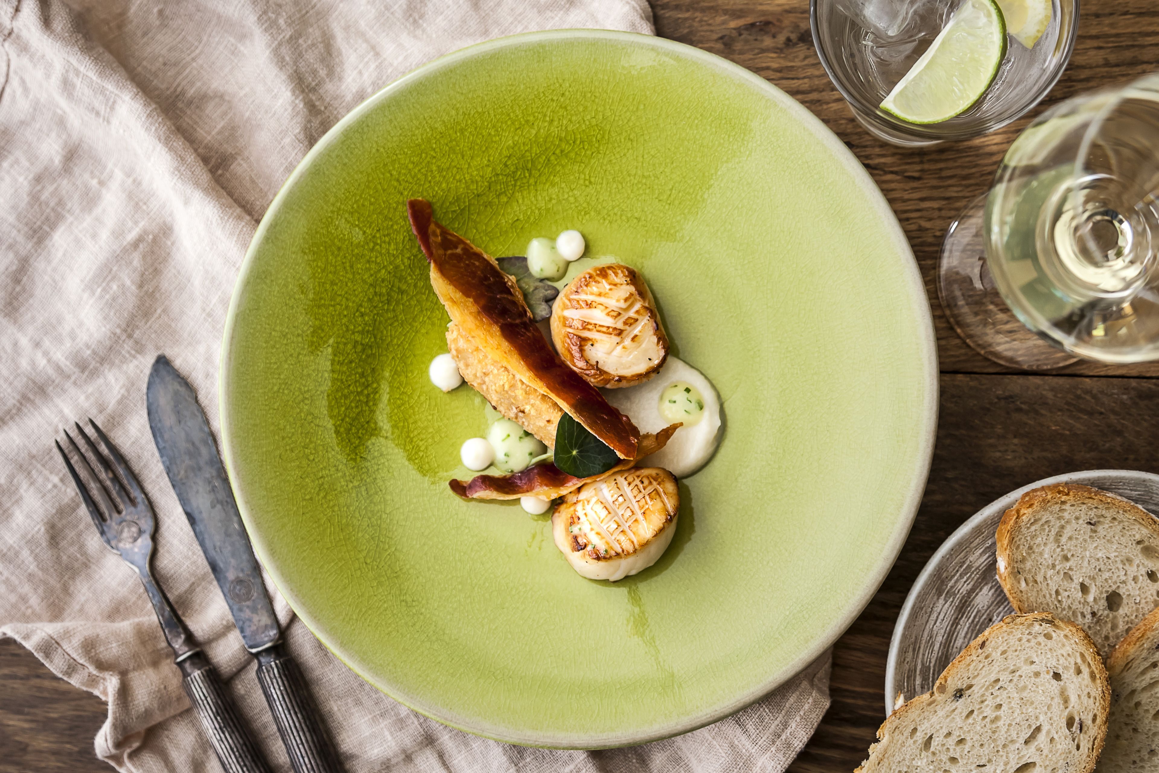 A plate with food and a fork on a cloth.