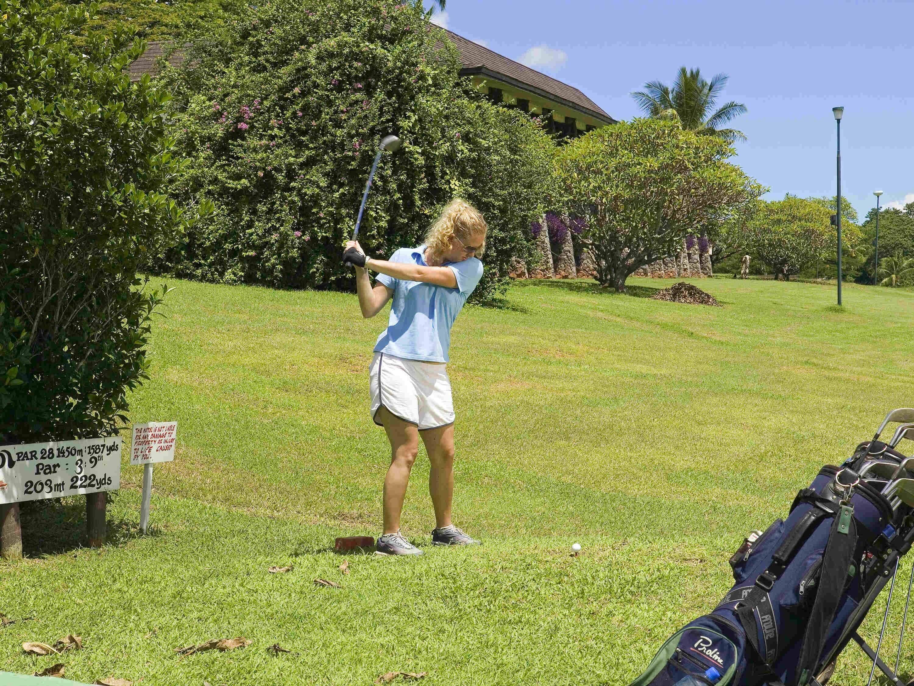 Un campo da golf con un cartello che indica un par 3, buca da 9 pollici, 203 metri e 222 iarde.