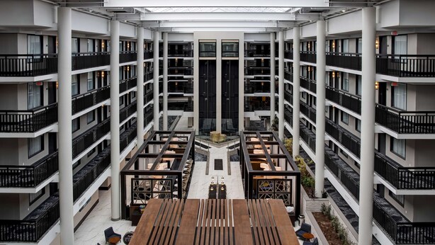 Un atrium à plusieurs niveaux, doté d’un espace central ouvert, entouré de balcons et d’espaces de détente.