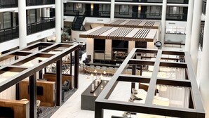 Un hôtel à plusieurs niveaux, avec un atrium central, de nombreux balcons et un espace bar.