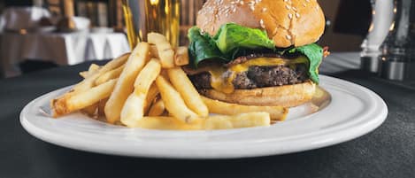 Een bord met een hamburger en frieten op een tafel in een restaurant.