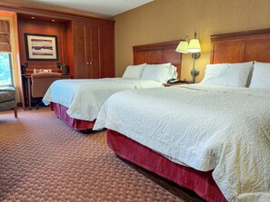 A hotel room with two beds, a desk, a chair, and a lamp. - Par-A-Dice Inn (East Peoria)