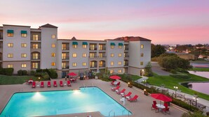 A hotel with a swimming pool, outdoor seating, and a view of the surrounding area. - Embassy Suites by Hilton Temecula Valley Wine Country (Temecula)