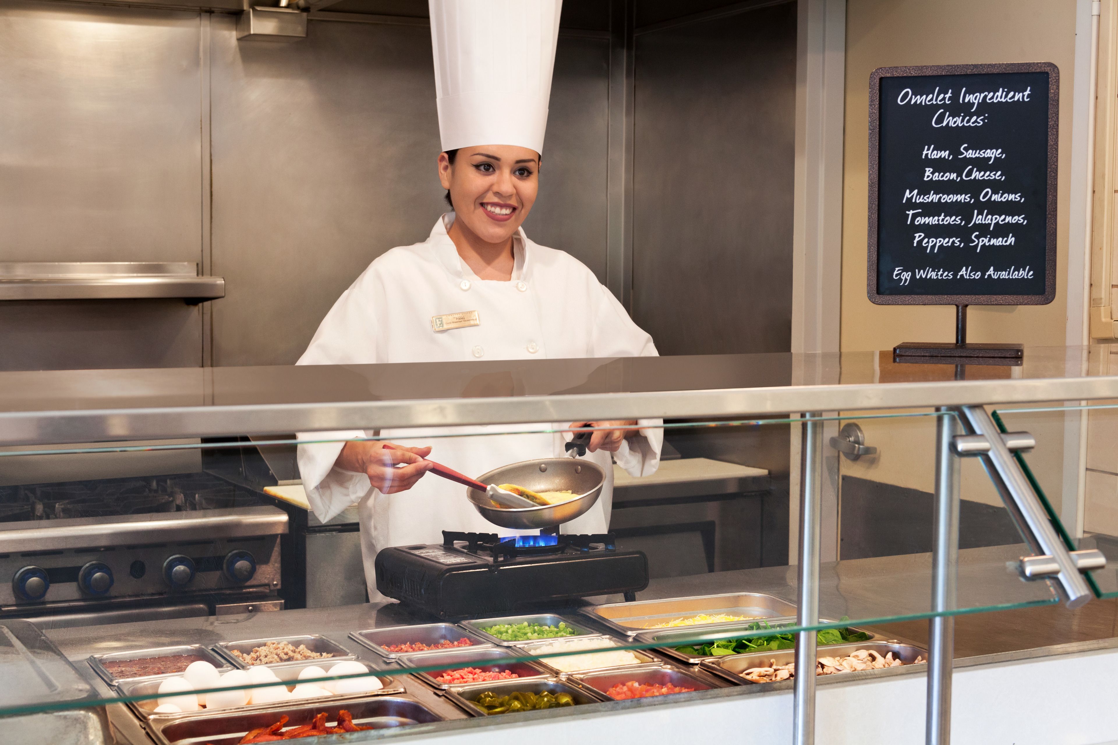 Un chef en una cocina profesional, con una pizarra mostrando los ingredientes para tortillas.