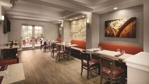 A restaurant with a modern interior, featuring wooden flooring, white tables, and red cushioned seating. - Embassy Suites by Hilton Temecula Valley Wine Country (Temecula)