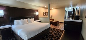 A hotel room with a large bed, bedside tables, a desk, a chair, a sofa, and a TV. - Comfort Inn & Suites Shakopee Downtown Area (Shakopee)